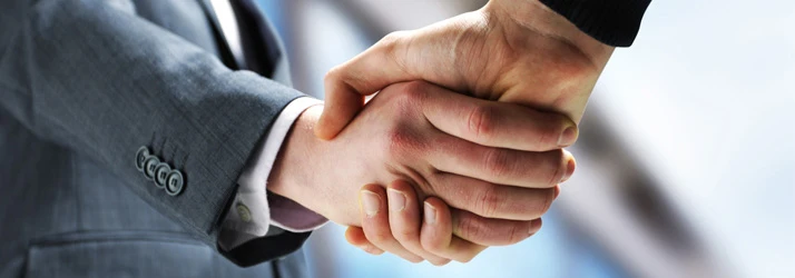 Close-up of a handshake between two people, symbolizing agreement or partnership.